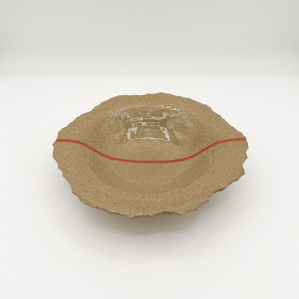 Ceramic plate with a textured surface and red accent on a white background