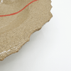 close up of stoneware plate with red line detail on white background