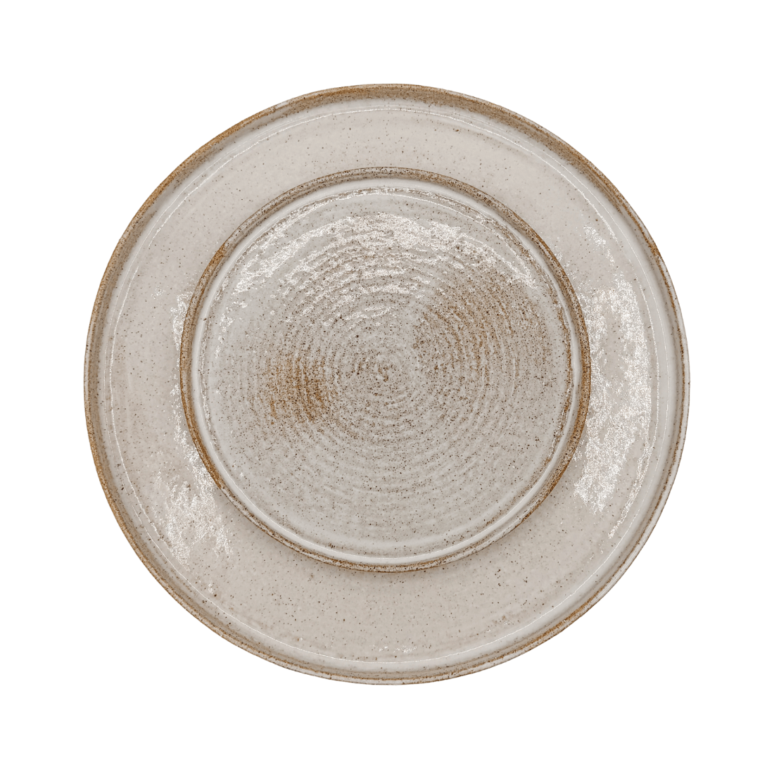 Round ceramic plate with textured surface on a white background