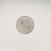 Round ceramic plate with textured edge on a white background