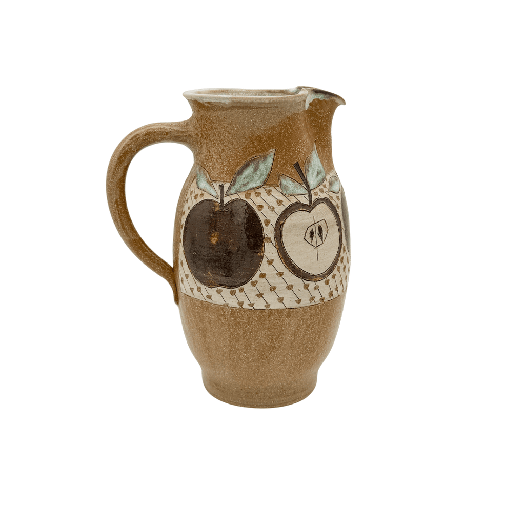 Ceramic pitcher with apple design on a white background