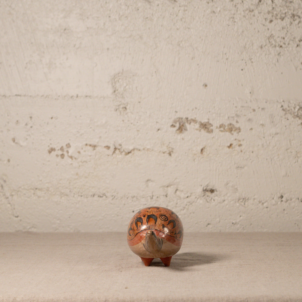 Small decorative armadillo with intricate designs on a textured surface