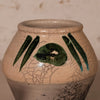 A handmade ceramic planter pot with a beige crackled glaze, featuring green painted abstract leaf-like stripes and a central green oval motif on the front.