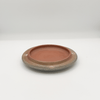 Ceramic plate with speckled texture on a white background