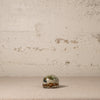 Small ceramic turtle with floral design on a textured surface