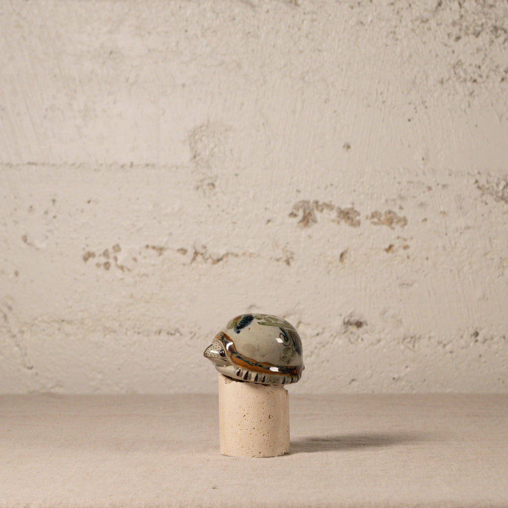 Decorative ceramic turtle with a shell design on a textured surface