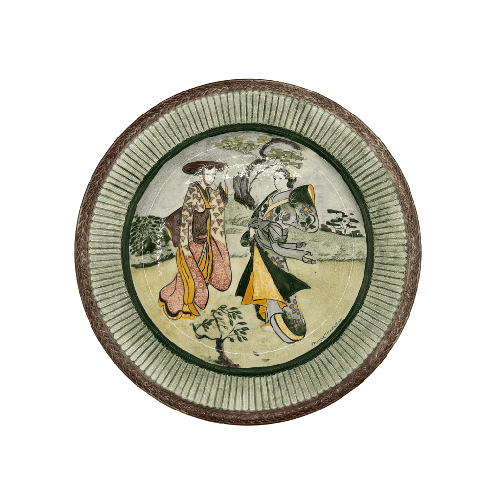 Decorative plate with a traditional design of two figures and a dog on a white background