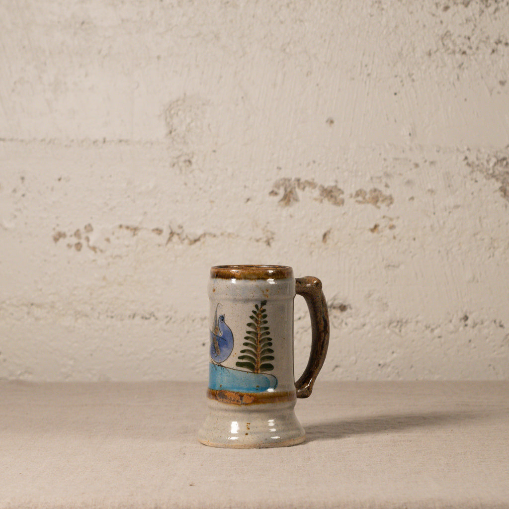 Ceramic mug with decorative elements on a textured surface