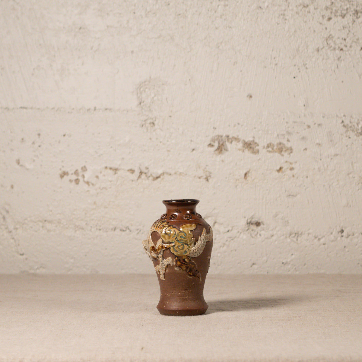 Decorative vase with floral patterns on a textured surface