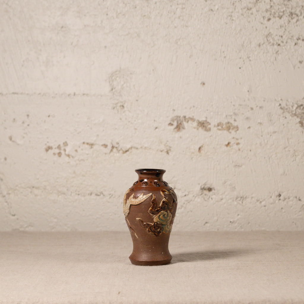 Decorative vase with floral patterns on a textured surface