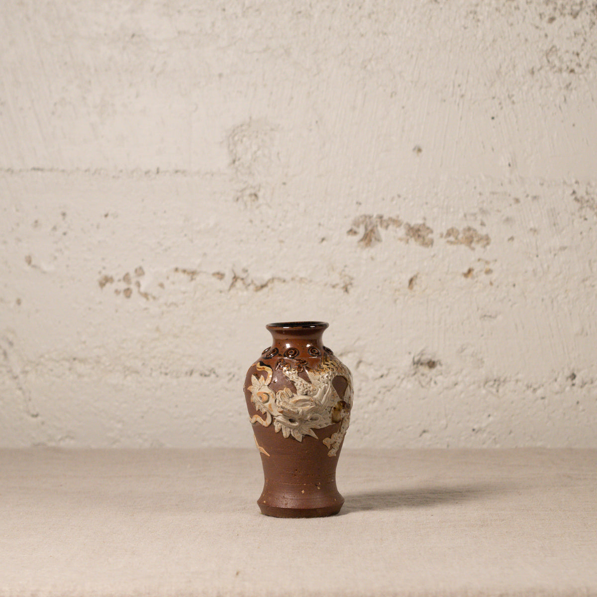 Decorative vase with floral patterns on a textured surface and background