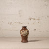Decorative vase with floral patterns on a textured surface and background