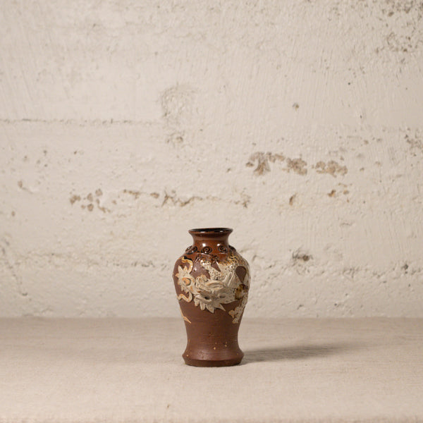 Decorative vase with floral patterns on a textured surface and background