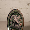 Decorative plate with deer and floral design on a textured surface