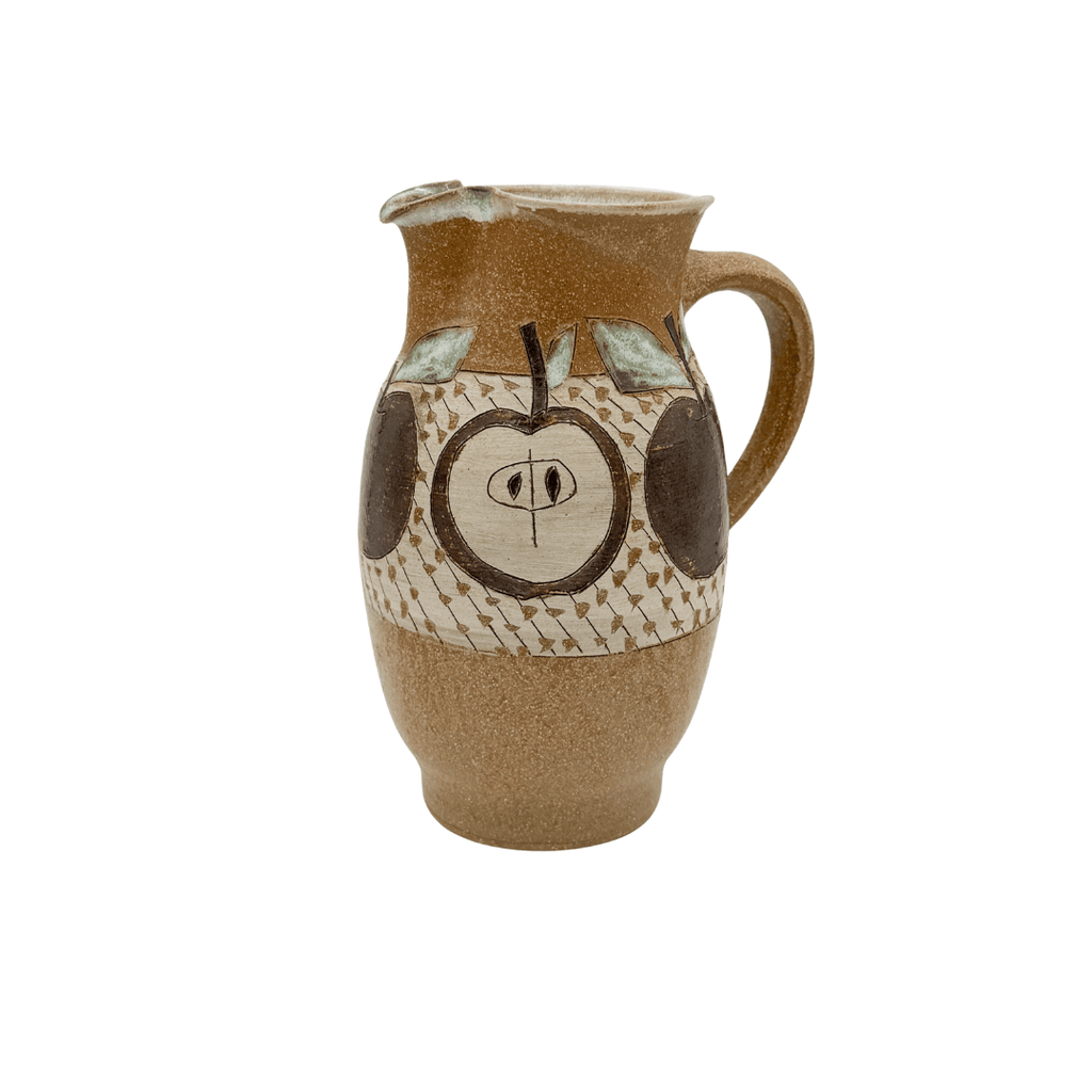 Ceramic pitcher with apple design on a white background
