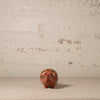 Small ceramic armadillo with decorative design on a textured surface
