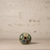 Decorative ceramic vase with floral patterns on a textured surface