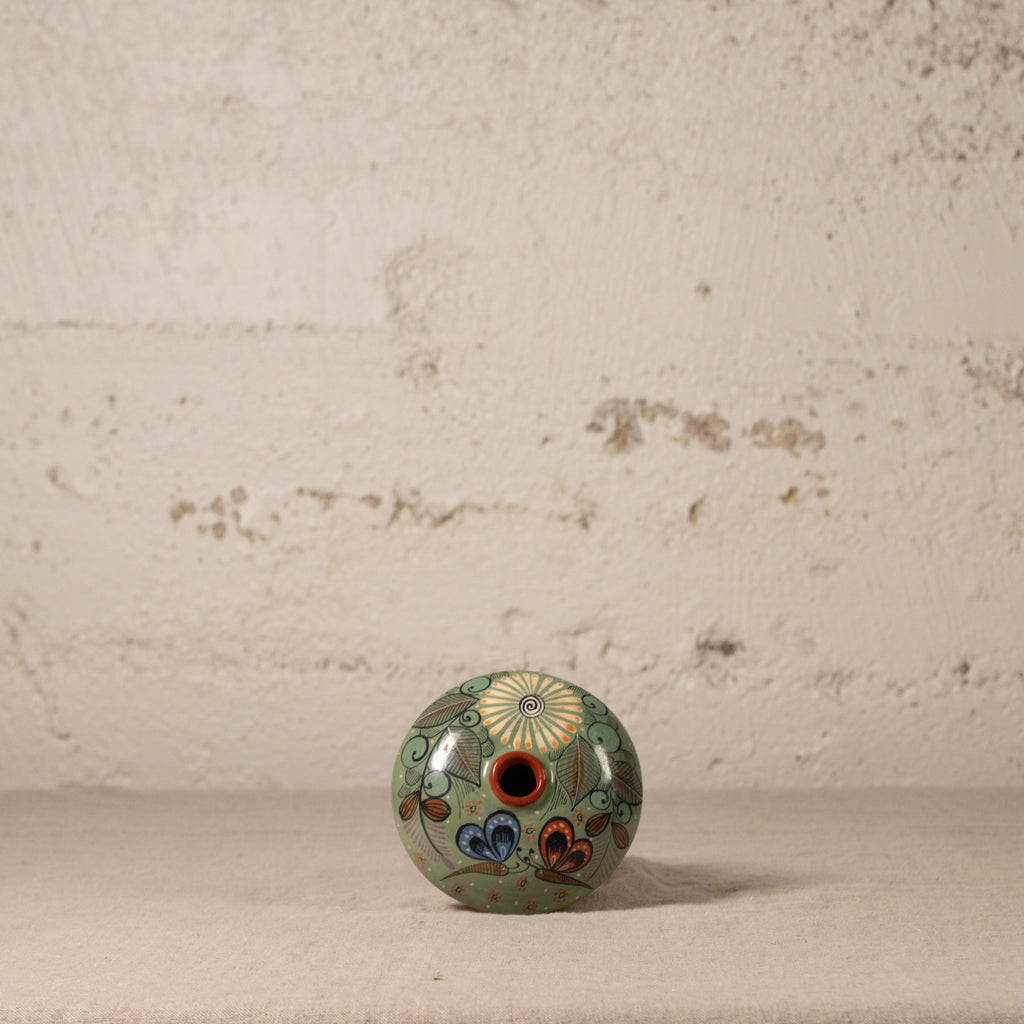 Decorative ceramic vase with floral patterns on a textured surface