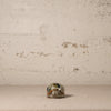 Small decorative turtle on a textured surface with a neutral background