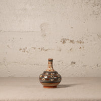 Decorative ceramic vase with floral patterns on a textured surface and light gray background