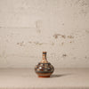 Decorative ceramic vase with floral patterns on a textured surface and light gray background