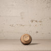 Small ceramic cup with 'MEXICO' written on it against a textured beige wall.