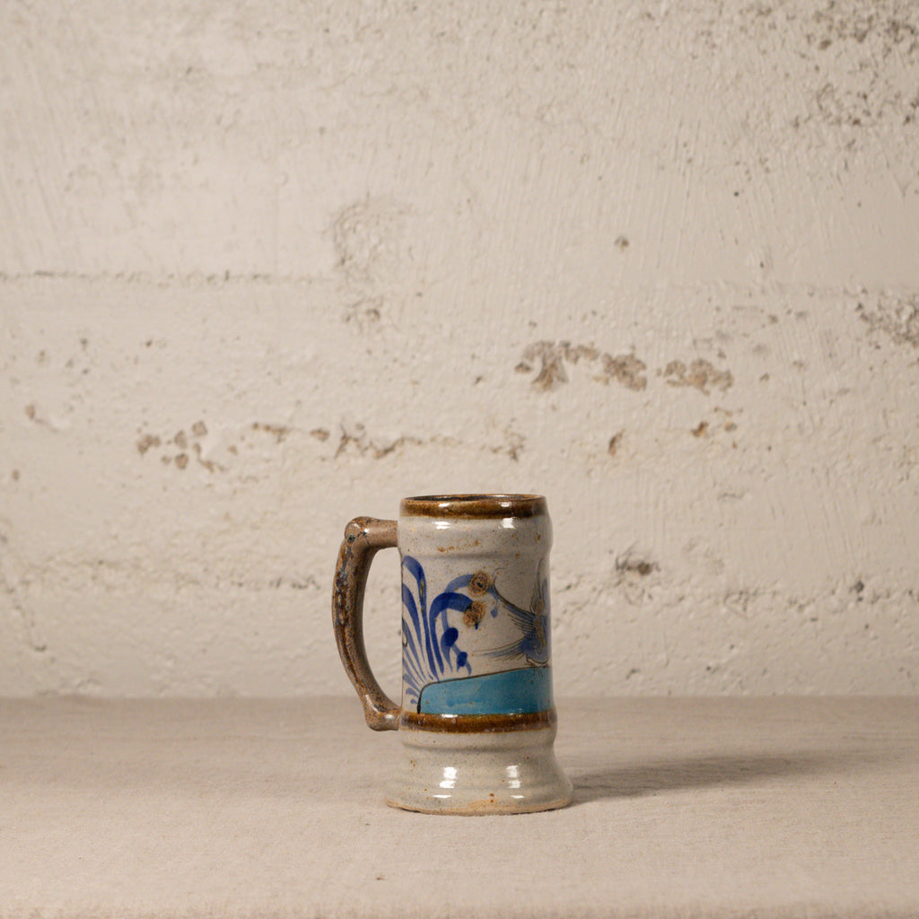 Ceramic mug with decorative design on a textured surface