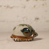 Ceramic turtle figurine with decorative shell on a neutral background