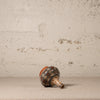 Ceramic vase with decorative patterns on a textured surface and background
