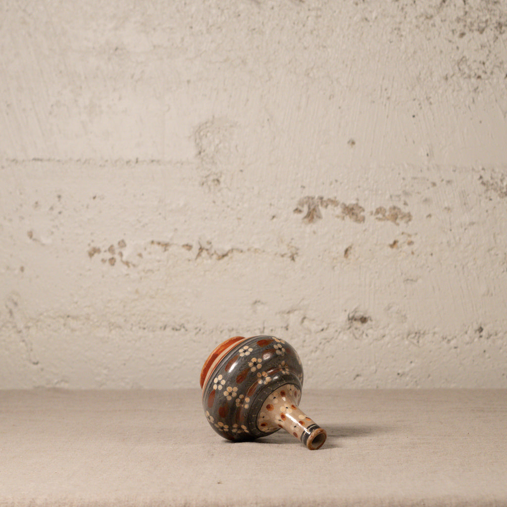 Ceramic vase with decorative patterns on a textured surface and background
