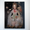 A vertical canvas painting hanging on a white wall, depicting a stylized woman in a pale dress against a dark background with surreal floral and celestial details.