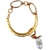 Gold half cuff bracelet with a pearl charm on a white background