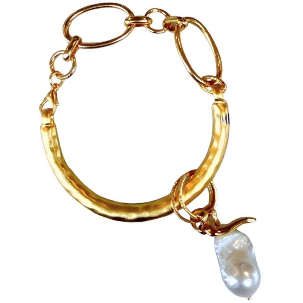 Gold half cuff bracelet with a pearl charm on a white background