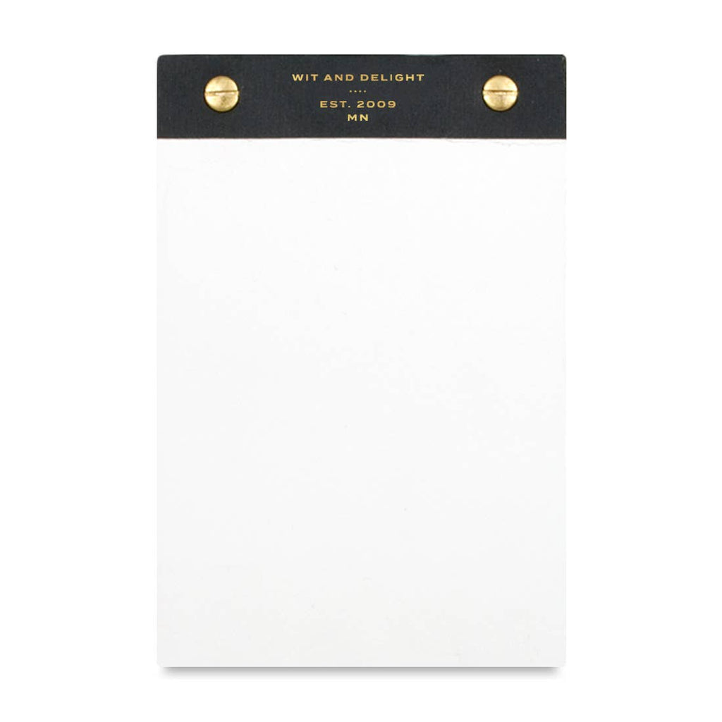 A white notepad with a black top header band featuring gold text that reads 'WIT AND DELIGHT EST. 2009 MN' and two gold rivets on either side, shown on a plain white background.