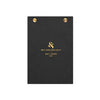 A black textured clipboard with gold metal grommets at the top and gold foil branding for 'Wit and Delight' in the center, shown on a plain white background.