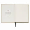Open notebook with a blank page and text on a white background