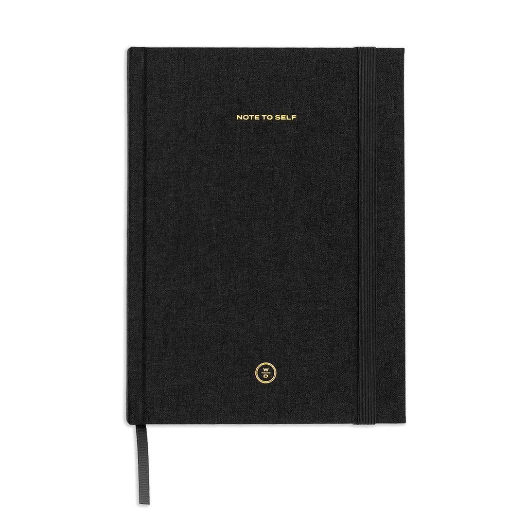 A black textured hardcover notebook with gold foil lettering that reads 'NOTE TO SELF' and a small circular gold logo near the bottom, shown on a plain white background.