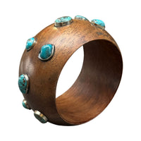 Wooden bracelet with turquoise stones on a white background