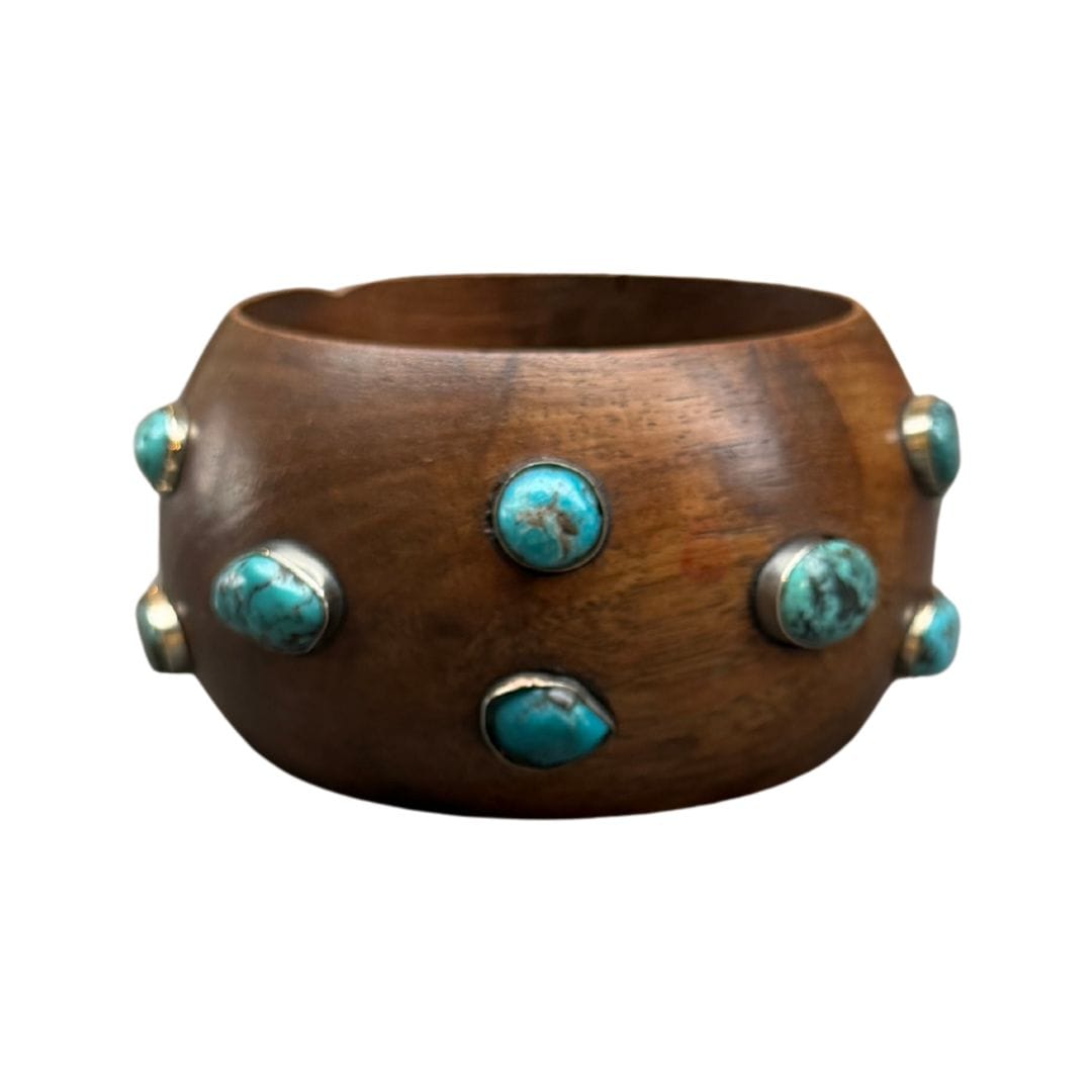 Wooden bracelet with turquoise stone embellishments on a white background