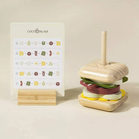 Wooden toy hamburger with a stand and COCO VILLAGE branding on a beige background