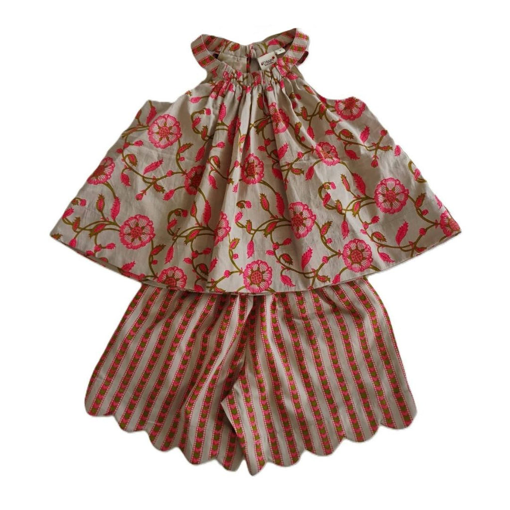 A two-piece children's outfit featuring a sleeveless top with a pink floral print on a beige background and matching striped shorts with scalloped edges.