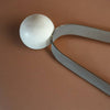 Metallic spoon with a round head on a brown background