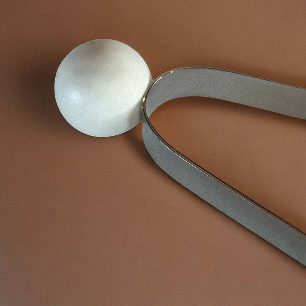 Metallic spoon with a round head on a brown background
